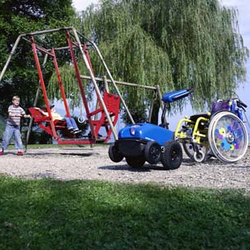 Hjælpemotor til kørestol til børn på en legeplads