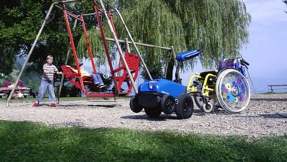 Hjælpemotor til kørestol til børn på en legeplads